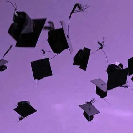 Photo de chapeaux de diplômés lancés dans les airs.